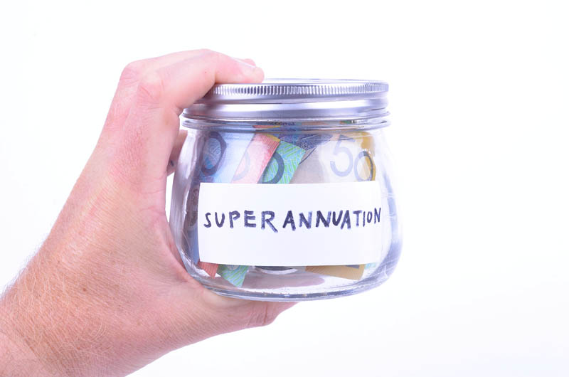 A man holds a jar full of Australian cash with a superannuation label on the front.